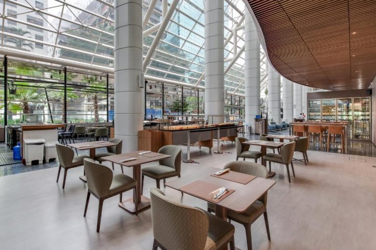 Restaurante con atrio acristalado y mesas elegantes del Radisson São Paulo Paulista