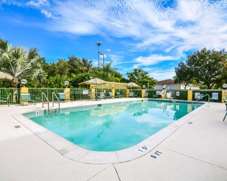 Piscina exterior con tumbonas y zona de descanso del Comfort Suites Tampa Brandon en Florida
