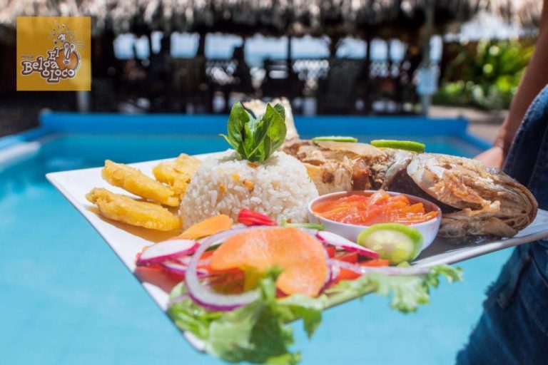 Plato típico de pescado frito con arroz y patacones junto a la piscina del Hostal El Belga Loco