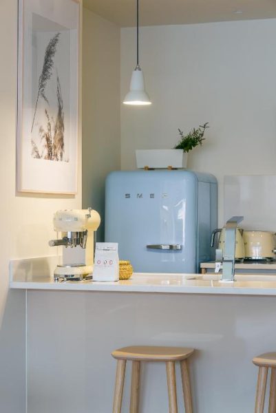 Cocina con barra americana, nevera vintage Smeg azul y cafetera en Three House Hotel