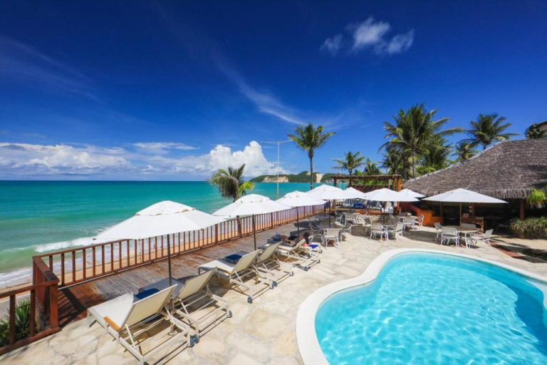 Piscina exterior con terraza frente al mar turquesa del Manary Praia Hotel en Natal, Brasil