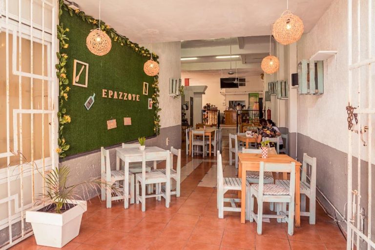 Restaurante Epazzote del Hotel Maya Turquesa con decoración de pared verde y mesas de madera