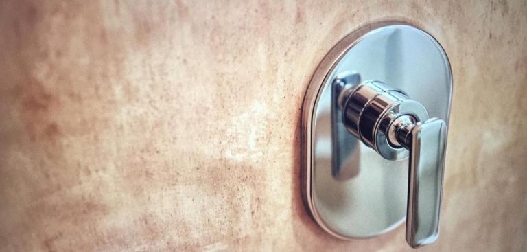 Grifo de ducha empotrado en cromo del baño de Casa Altamar con acabados en piedra natural