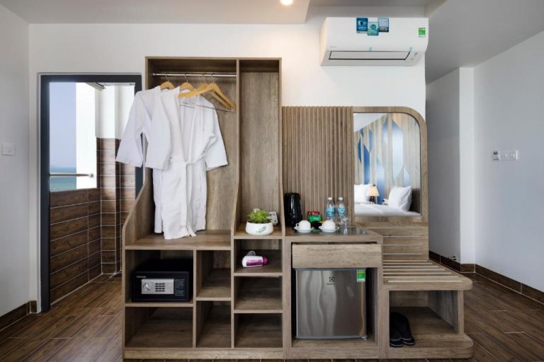 Armario con batas de baño, minibar y zona de café en habitación del Azura Gold Hotel & Apartment