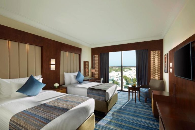 Habitación twin con dos camas y vistas a la ciudad en el Royal Tulip Muscat