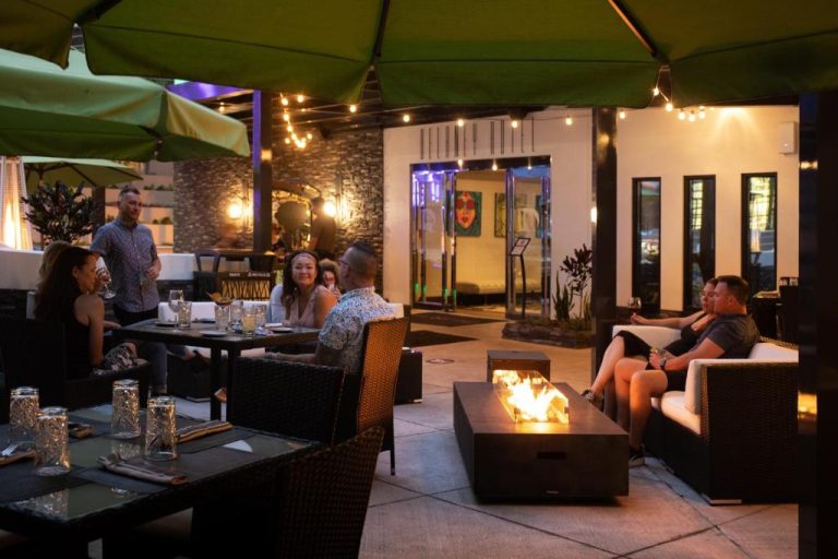 Terraza exterior con chimenea y ambiente nocturno en The Delaney Hotel, ideal para cenar al aire libre