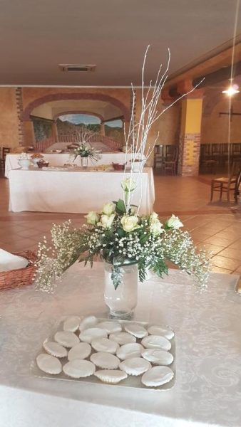 Salón de eventos del Hotel Le Tre Rose decorado con flores blancas y galletas para celebración de boda