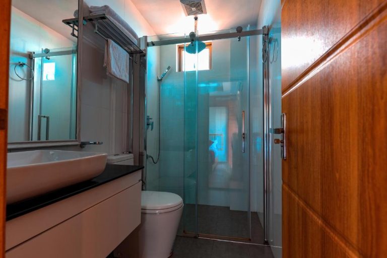 Baño completo con ducha de cristal, lavabo y aseo moderno en el hotel Araamview