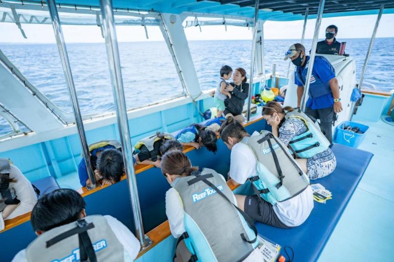Pasajeros con chalecos salvavidas en excursión en barco al arrecife en Hotel Monterey Okinawa Spa Resort