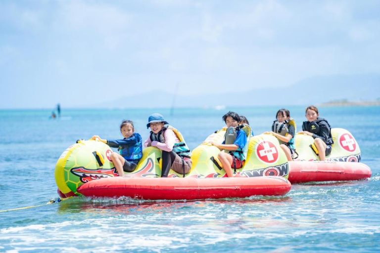 Niños disfrutando del banana boat en las actividades acuáticas del Hotel Monterey Okinawa Spa & Resort