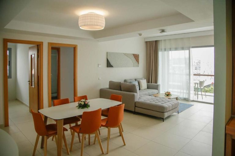 Salón comedor moderno con sofá gris y sillas naranjas en el hotel Zephyr Agadir
