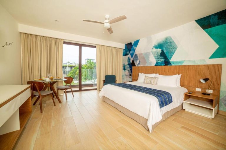 Habitación king size con arte moderno y balcón con vista en Lahun Suites Playa del Carmen