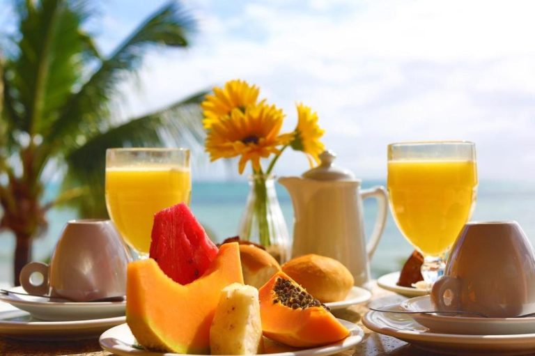 Desayuno tropical con frutas frescas y zumo de naranja en Manary Praia Hotel con vista al mar