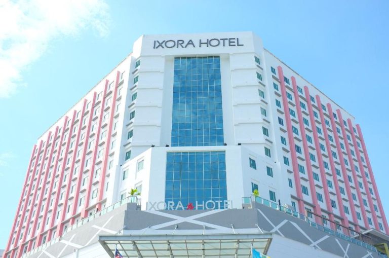 Fachada exterior del Ixora Hotel Penang con cristaleras azules y detalles en rosa