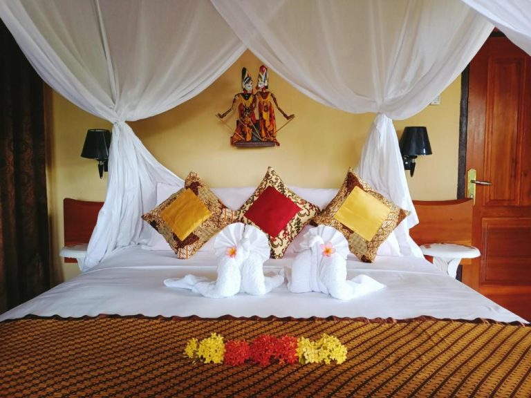 Habitación con cama de dosel y decoración balinesa tradicional en Tangkoko Sanctuary Villa