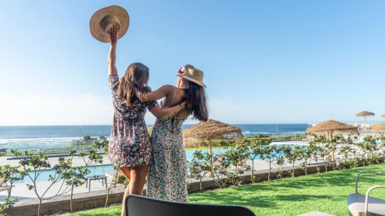 Dos amigas disfrutando de la piscina exterior con vistas al mar en el Hotel Verde Mar & SPA