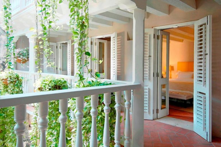 Balcón colonial con barandilla blanca y plantas tropicales del Hotel Casa Don Sancho By Mustique
