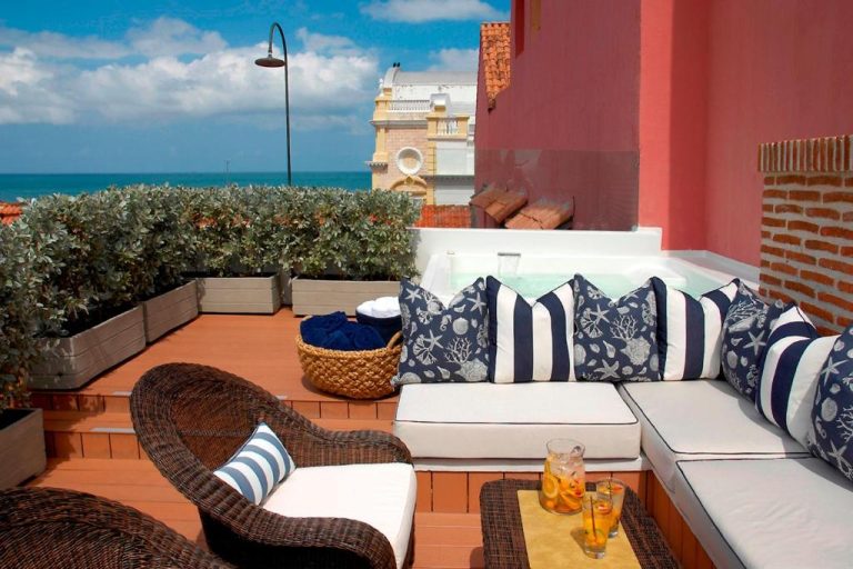 Terraza con jacuzzi y sofás con cojines náuticos del Hotel Casa Don Sancho By Mustique con vistas al mar