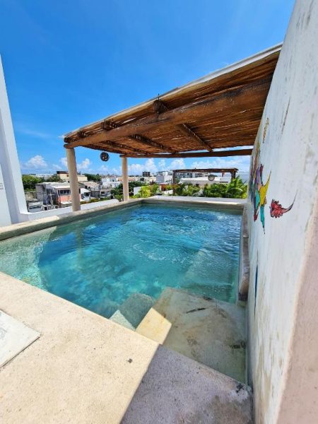 Piscina en azotea con pérgola de madera y vistas panorámicas de la ciudad en Hotel Playa Nah