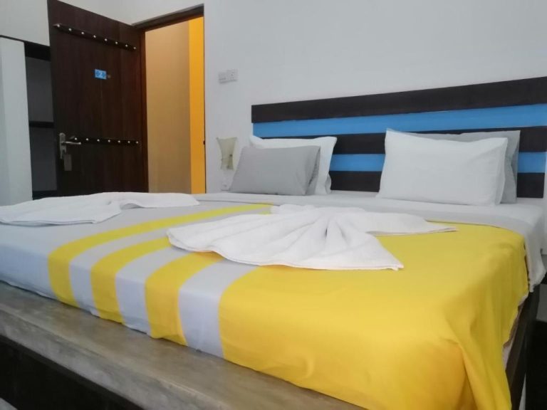 Habitación doble con cama amplia y cabecero azul en Le Petit Hotel & Restaurant