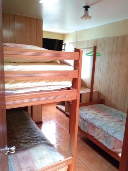 Habitación con literas de madera y cama individual en Hospedaje Del Pilar en Magdalena del Mar