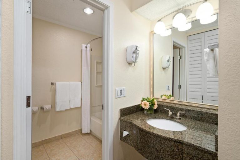 Baño completo con ducha, lavabo de granito y secador de pelo en Comfort Suites Paradise Island