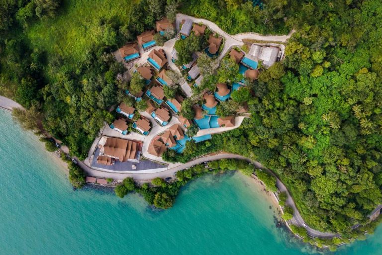 Vista aérea de las villas tropicales del SINAE Phuket Luxury Hotel rodeadas de selva y mar turquesa
