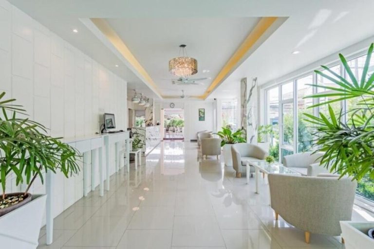Luminoso lobby y recepción del Park 38 Hotel con decoración blanca, plantas tropicales y zona de descanso
