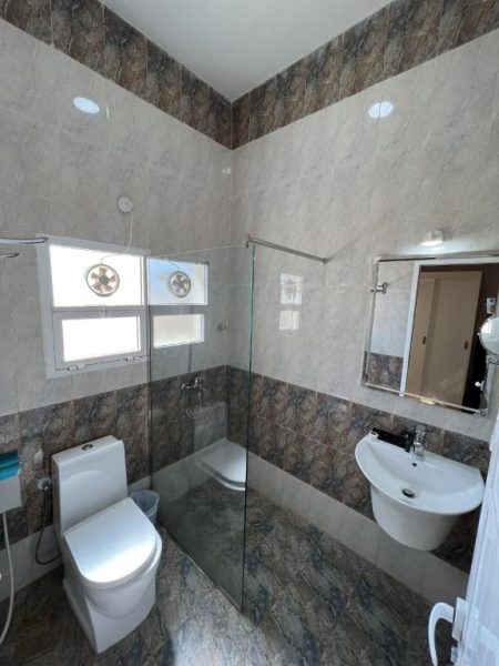 Baño completo con ducha de cristal, inodoro y lavabo del Ibra Plaza Hotel