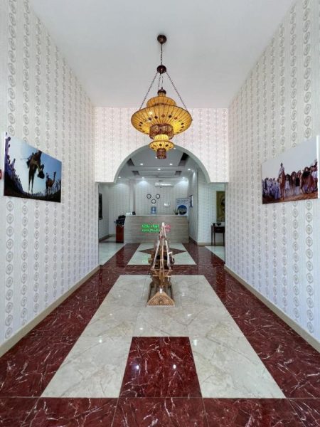 Lujoso lobby del Ibra Plaza Hotel con suelo de mármol, lámpara artesanal y decoración árabe tradicional