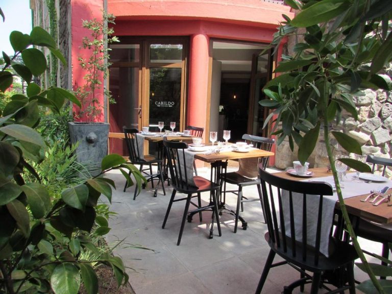 Terraza exterior del restaurante Cabildo en Hotel Boutique Castillo Rojo con mesas y jardín