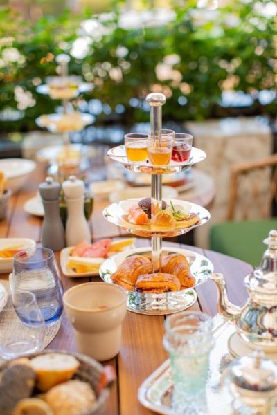 Desayuno buffet con torre de pasteles y croissants en terraza exterior del Hotel Jadali & Spa