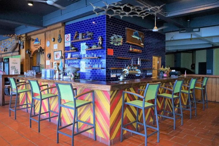 Bar tropical con taburetes coloridos y azulejos azules en Ramada by Wyndham Langkawi Marina
