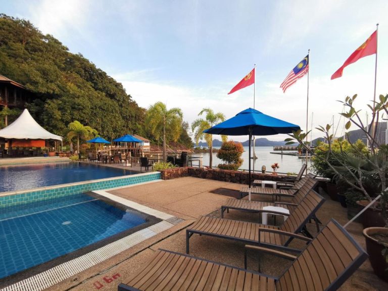 Piscina exterior con tumbonas y vistas al mar del Ramada by Wyndham Langkawi Marina
