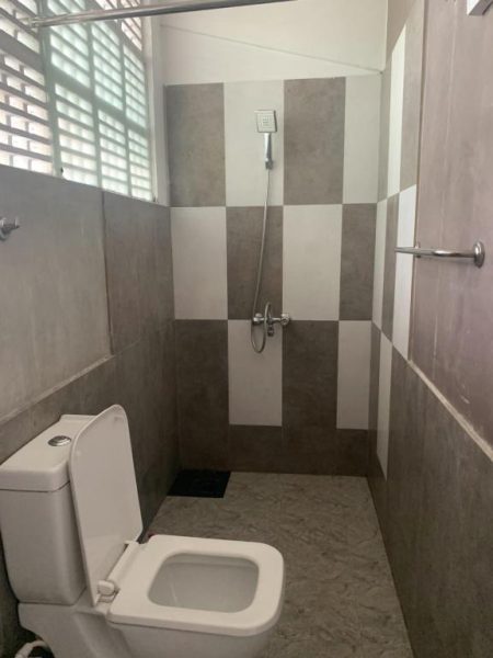Baño completo con ducha y sanitario moderno en 360 Beach Residence con azulejos grises