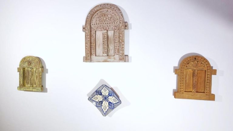 Decoración artesanal con puertas de madera tallada y azulejo pintado a mano en Shaba Boutique Hotel