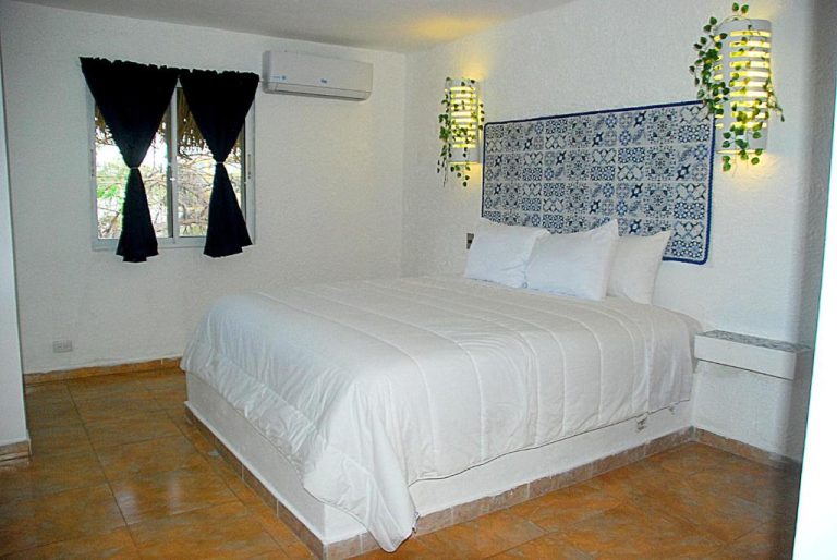 Habitación doble con cama king size y cabecero de azulejos en Nuovo Hotel Playa Catalina