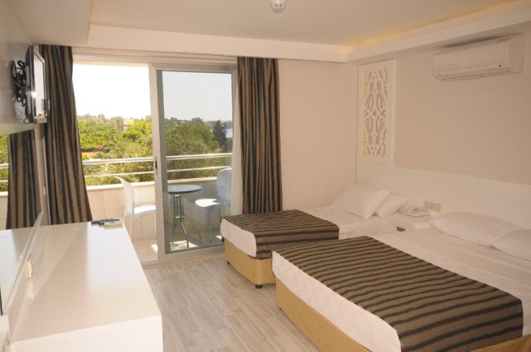 Habitación twin con balcón y vistas al jardín en Aura Boutique Hotel, con dos camas y aire acondicionado