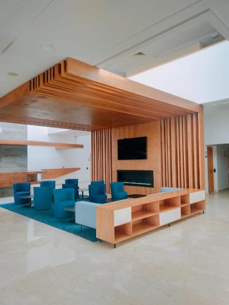 Lobby del Hotel Zephyr Agadir con estructura de madera, chimenea moderna y sillones azules