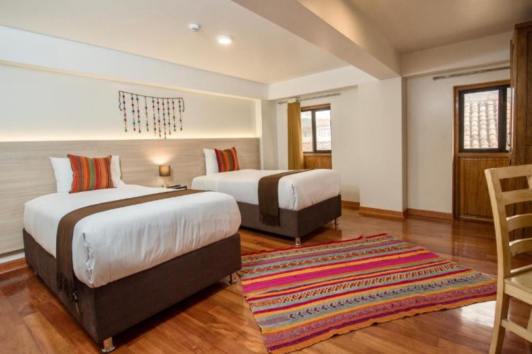 Habitación doble con decoración andina y suelo de madera en Casa Matara Boutique Hotel