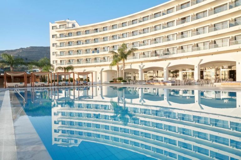 Piscina exterior con reflejo del edificio principal del Lindos Bay Hotel en Rodas, Grecia