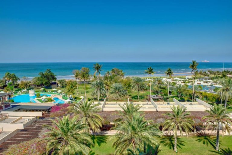 Vista aérea de la piscina exterior y jardines tropicales del InterContinental Muscat frente al mar