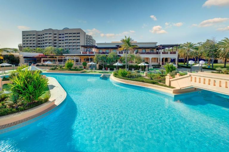 Amplia piscina exterior con jardines tropicales del InterContinental Muscat by IHG en Omán