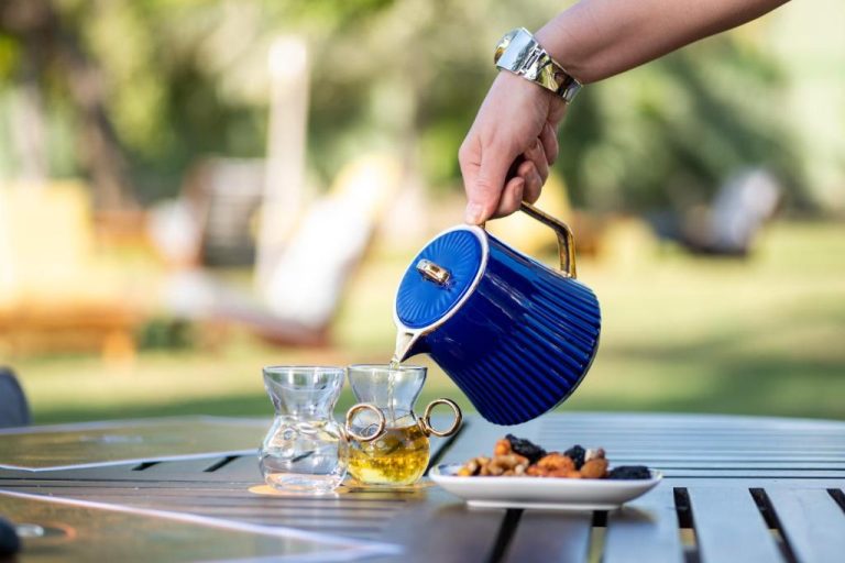 Servicio de té con tetera azul y frutos secos en la terraza exterior del InterContinental Muscat