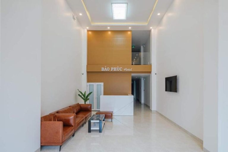 Recepción y lobby moderno del Bao Phuc Hotel con sofás de cuero marrón y mostrador de mármol