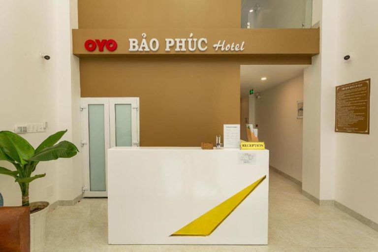 Recepción moderna del Bao Phuc Hotel con mostrador blanco y dorado y señal de bienvenida