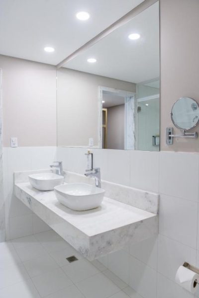Baño doble con lavabos sobre encimera de mármol blanco en Bisinii Boutique Hotel