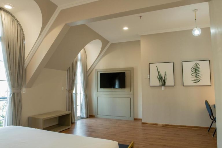 Habitación superior con arco decorativo y televisión en Bisinii Boutique Hotel