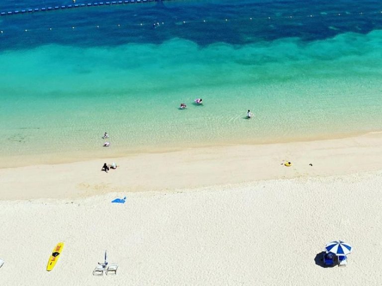 Playa de arena blanca con aguas turquesas cristalinas del Hotel Monterey Okinawa Spa & Resort