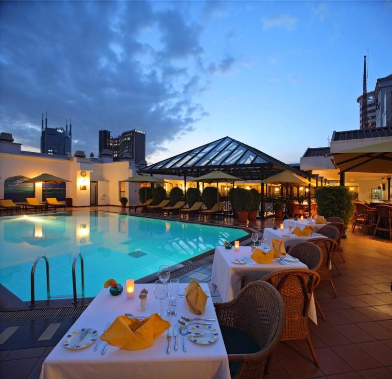 Piscina exterior y restaurante terraza al atardecer en el Sarova Stanley Hotel de Nairobi